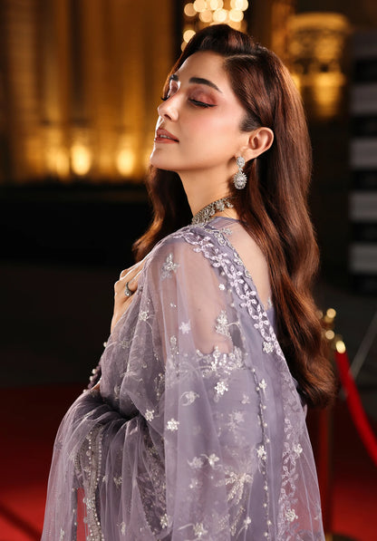 Woman in a light purple embroidered dress with a blurred background