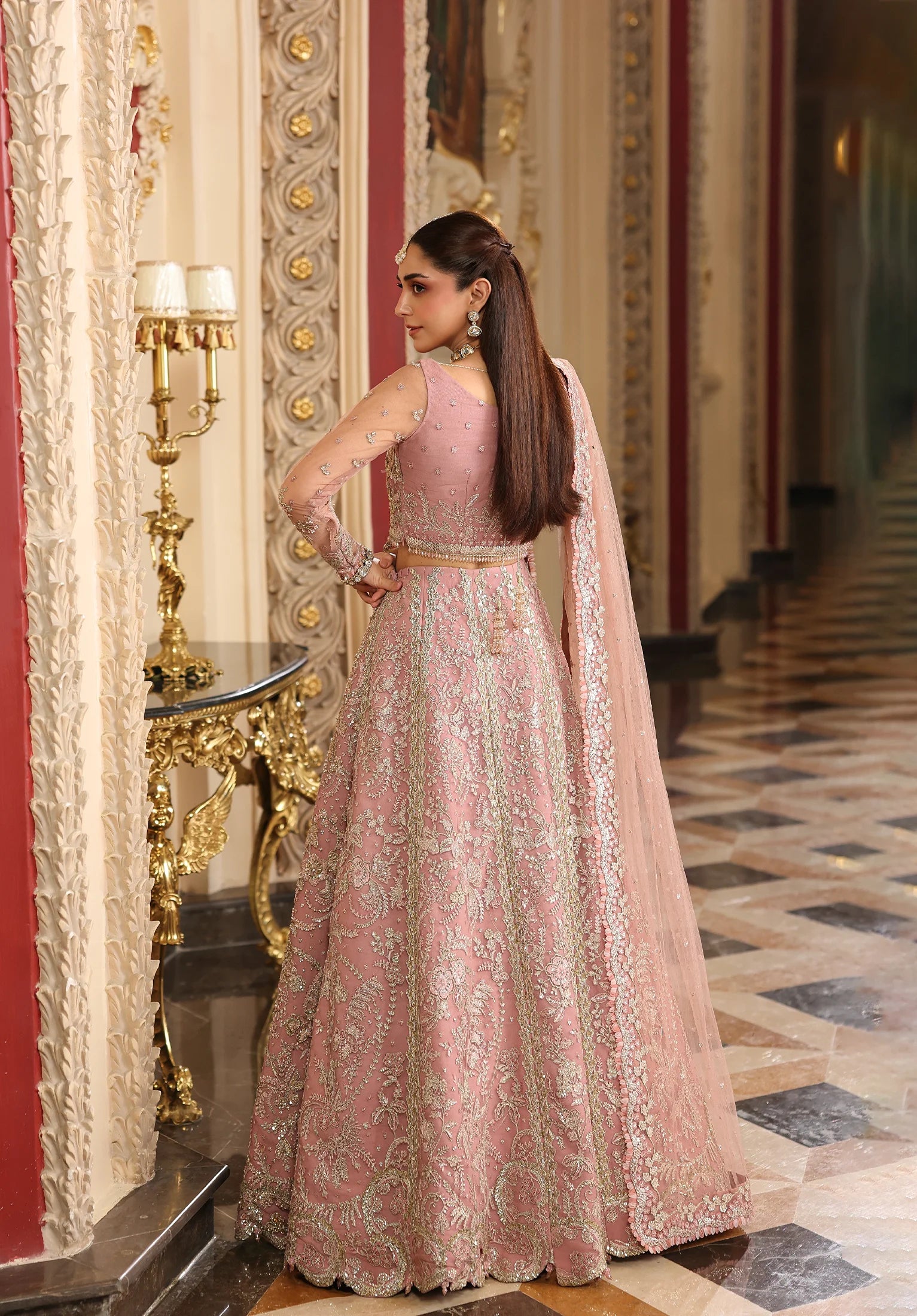 Woman in a Elaf Stardom Handwork traditional outfit standing in an ornate room.